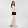 A woman models a black Guess handbag. Produktbild-Vorschau