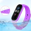 A purple smart band is shown partially submerged in water, with a close-up inset showing ventilation holes. Voir les images du produit