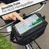 A person's hand is shown touching a smartphone mounted on a bicycle handlebar bag, displaying a map. Podgląd zdjęcia produktu