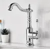 A chrome faucet with a white handle sits on a countertop next to a small potted plant and a bottle. Produktbild-Vorschau