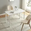 A white dining table with two beige chairs in a room with a light gray wall and a striped rug. Produktbild-Vorschau