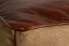 Close-up view of the corner of a pouf, showing the texture and stitching of the leather and canvas materials. Produktbild-Vorschau
