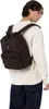 A man wearing a white sweatshirt and dark blue jeans is seen from the back, wearing a brown backpack. Anteprima dell’immagine prodotto