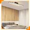 A bedroom scene with a bed, wooden wall paneling, and a modern ceiling light. Podgląd zdjęcia produktu