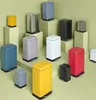A collection of various colored metal pedal bins arranged on a light green background. Voir les images du produit