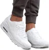 A pair of white sneakers worn by a person, shown from the ankle down. Produktbild-Vorschau