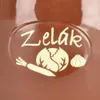 A close-up of a brown ceramic container with a cream-colored oval label featuring text and illustrations of vegetables. Náhled obrázku produktu