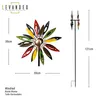A colorful metal wind spinner shaped like a flower, shown with dimensions and a brand logo. Produktbild-Vorschau