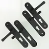 Two pairs of black door handles with escutcheons are arranged diagonally on a white background. Náhled obrázku produktu