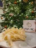 A plate of pasta in front of a Christmas tree with ornaments and lights. Voir les images du produit
