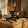 A collection of cookware arranged on a wooden countertop in a kitchen. Podgląd zdjęcia produktu