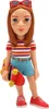 A figurine of a young girl with red hair, wearing a striped shirt and blue shorts, holding a skateboard. Podgląd zdjęcia produktu