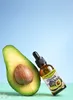 A bottle of avocado oil next to a halved avocado. Anteprima dell’immagine prodotto