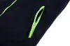 A close-up view of a dark blue fleece jacket pocket with a bright green zipper. Voir les images du produit