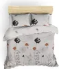 A top-down view of a duvet cover and pillow set with a floral and butterfly pattern, laid on a bed with a wooden headboard. Podgląd zdjęcia produktu