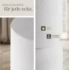 A close-up of a white cylindrical object, likely a side table, with text overlays highlighting features. Náhled obrázku produktu