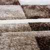 A close-up view of a textured rug with a geometric pattern. Voir les images du produit