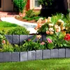 A garden bed with stone-look plastic edging and various flowers and plants. Náhled obrázku produktu