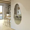 A modern dining room and kitchen area with a unique, irregularly shaped mirror reflecting the dining table and chairs. Produktbild-Vorschau