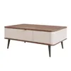 A modern coffee table with a wooden top and a cream-colored body with a ribbed drawer front and gold handle, supported by black metal legs. Voir les images du produit