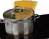 A stainless steel pot with a glass lid containing uncooked spaghetti is placed on a black glass ceramic stovetop. Produktbild-Vorschau