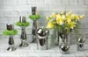 A collection of decorative items including candle holders, spheres, and a floral arrangement, displayed against a brick wall. Produktbild-Vorschau