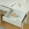 A close-up view of an open drawer in a white vanity table, revealing makeup products inside. Náhled obrázku produktu