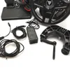 A collection of gaming accessories, including a steering wheel, pedals, power adapter, and cables, laid out on a white surface. Anteprima dell’immagine prodotto