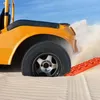 A yellow off-road vehicle is stuck in the sand, with an orange traction mat placed under the tire to help it get unstuck. Náhled obrázku produktu