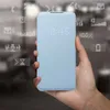 A hand holds a light blue smartphone case with a digital display showing the time and various icons. Anteprima dell’immagine prodotto