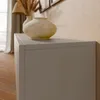 A close-up view of a modern gray cabinet with two decorative vases on top, set against a textured beige wall. Náhľad obrázku produktu
