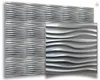 A display of silver-colored 3D wall panels with a wavy texture, arranged in a grid. Produktbild-Vorschau