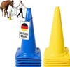 A horse and rider training with cones, with stacks of blue and yellow cones in the foreground. Náhľad obrázku produktu