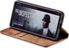 A smartphone in a brown flip case is displayed at an angle, showing a movie poster on its screen. Produktbild-Vorschau