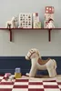 A nursery or playroom setting with toys on a shelf and on the floor. Produktbild-Vorschau