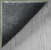 The underside of a rug is shown, partially covering a wooden surface. Produktbild-Vorschau