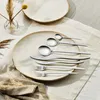 A set of silverware is laid out on a plate and a placemat. Voir les images du produit