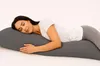 A woman sleeping on a long gray pillow. Produktbild-Vorschau