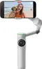 A smartphone is mounted on a gimbal, capturing a selfie of a woman and her dog on a beach. Podgląd zdjęcia produktu
