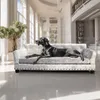 A black dog is lying on a luxurious silver sofa in a bright, modern hallway with large windows and architectural details. Podgląd zdjęcia produktu