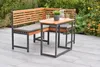 An outdoor seating set with a corner bench and a small table, placed on a patio with plants in the background. Produktbild-Vorschau
