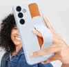 A person is holding a light blue phone case with an orange accent and a white grip. Produktbild-Vorschau