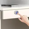 A hand is shown pressing a fingerprint lock on a white drawer. Podgląd zdjęcia produktu