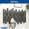 A modern black metal wall coat rack with a jacket hanging on one of the hooks. Produktbild-Vorschau