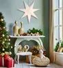 A festive Christmas scene with a decorated tree, presents, and a large paper star lantern hanging. Voir les images du produit