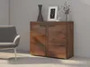 A wooden sideboard with two doors, decorated with a vase and a framed picture, next to a gray armchair. Produktbild-Vorschau