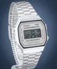 A close-up, angled shot of a silver Casio digital watch with a metal band against a dark gray background. Voir les images du produit