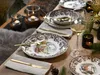 A beautifully set table with plates, cutlery, wine glasses, and candles, suggesting a festive or special occasion meal. Náhľad obrázku produktu