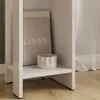 A close-up view of a white shelf with a book and a decorative object. Náhled obrázku produktu