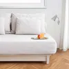 A white bed with pillows and a tray with a drink and fruit. Produktbild-Vorschau